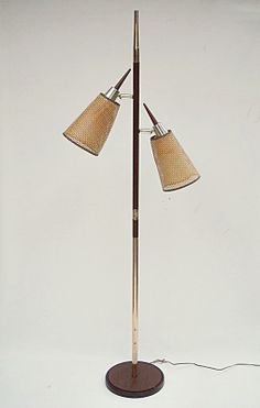 a floor lamp with two lamps on top of it