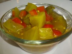 a glass bowl filled with sliced vegetables on top of a table