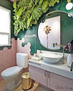 a bathroom decorated in pink, green and gold with palm trees on the wall above the sink