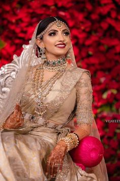 a woman in a bridal gown holding a pink ball and posing for the camera