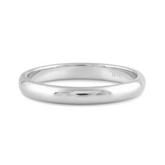 a white gold wedding band with the word w on it's center, in front of