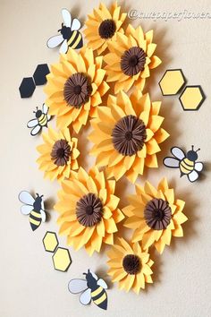 paper sunflowers and bees are arranged on the wall