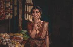 a woman standing in front of a bunch of flowers holding her hands to her mouth