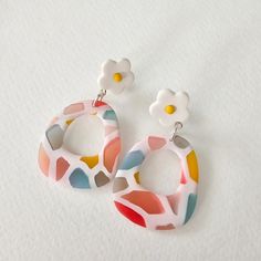 a pair of colorful earrings with flowers on them