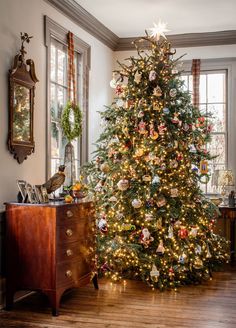 a christmas tree with ornaments on it in a living room