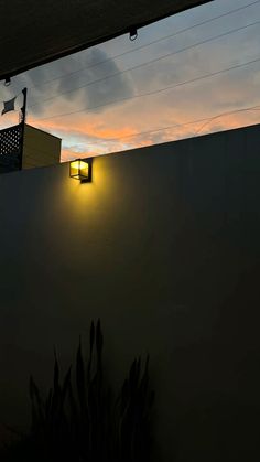 a street light that is on the side of a building at night with clouds in the background