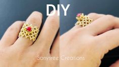 a woman's hand wearing a gold ring with red stones on it and the words, diy