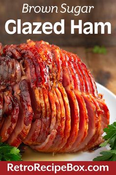 sliced ham on a white plate with parsley around it and the words, brown sugar glazed ham