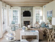 a living room filled with furniture and a flat screen tv mounted on the wall above a fireplace