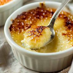 a spoon with some food in it on top of a white bowl filled with pudding