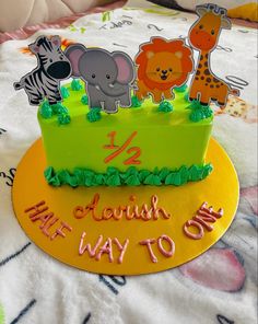 a birthday cake with animals on it sitting on a bed