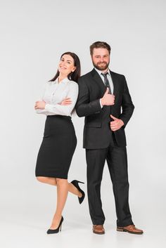 a man and woman in business attire posing for the camera