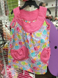 a child's dress hanging on a rack in a store