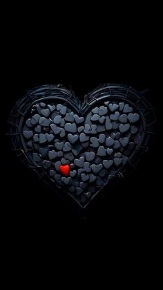 a heart made out of rocks with a red dot in the middle on a black background