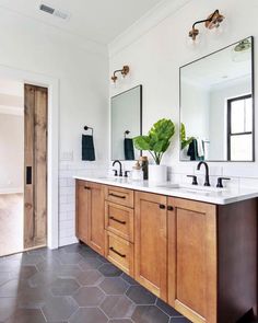 a bathroom with two sinks and mirrors in it