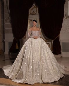 a model walks the runway in a white gown with sequins and beading