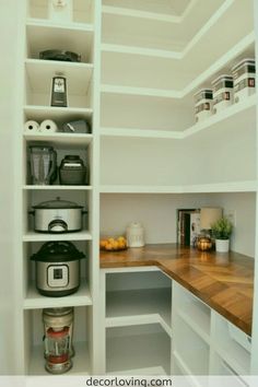 an organized pantry with white shelves and wooden counter tops