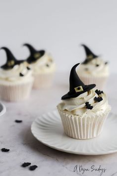 cupcakes with white frosting and black witches hats