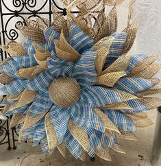 a large blue and gold flower sitting on top of a metal table next to a fence