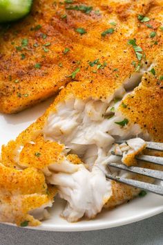 a white plate topped with fish and vegetables