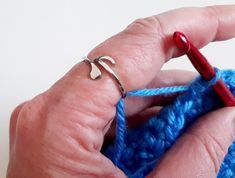 a person holding a crochet hook in their left hand and knitting the hook