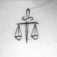 a black and white photo of a scale with the word justice written on it in cursive writing