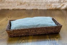 a wicker basket with a blue and white pillow