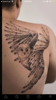 an owl tattoo on the back of a man