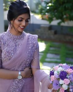 a woman in a purple dress holding a bouquet