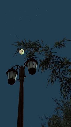 a street light with the moon in the background