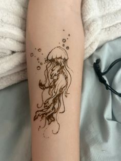 a woman's arm with a tattoo on it that has a jellyfish and bubbles