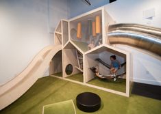 a man playing in a play room with a slide