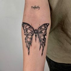 a black and white butterfly tattoo on the arm