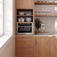 a kitchen with wooden cabinets and white dishes