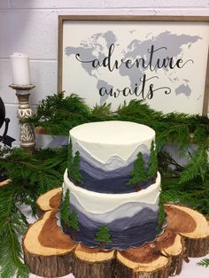 a three tiered cake sitting on top of a wooden table next to evergreen branches