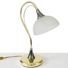 a lamp that is sitting on top of a white table next to a light bulb