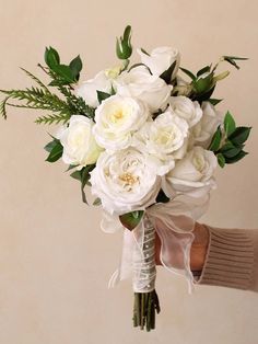 a person holding a bouquet of white flowers