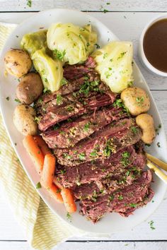 roast beef with potatoes and carrots on a plate next to a cup of tea