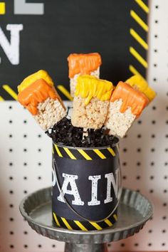 halloween treats in a bucket with candy sticks sticking out of it and black rice on top