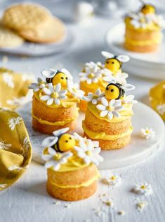 some little cakes with yellow frosting and flowers on them