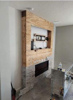 a room with a fire place in the middle and a wall mounted tv above it