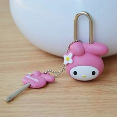 a pink hello kitty keychain with a white flower on it