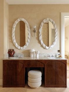 two circular mirrors on the wall in a bathroom