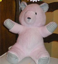 a pink teddy bear sitting on top of a table