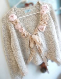 a white sweater with pink flowers on it