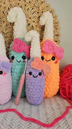 three crocheted stuffed animals sitting next to each other on a table with yarn