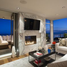 a living room with a fireplace and large windows