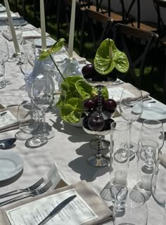 the table is set with glasses, plates and silverware