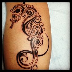 a tattoo design on the leg of a woman with swirls and an initial letter s