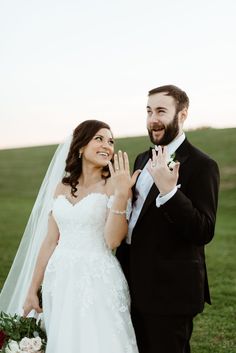 a bride and groom posing for the camera with their hands up in front of them